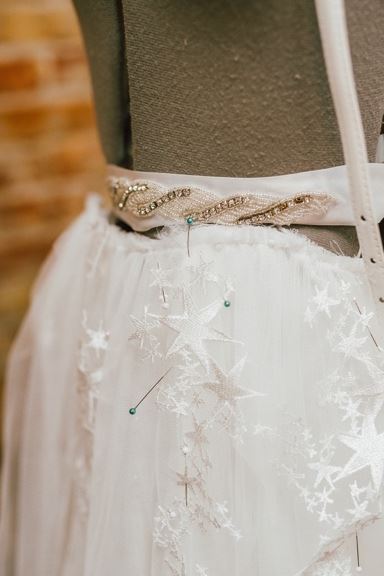 White fabric with star embellishments and beaded belt