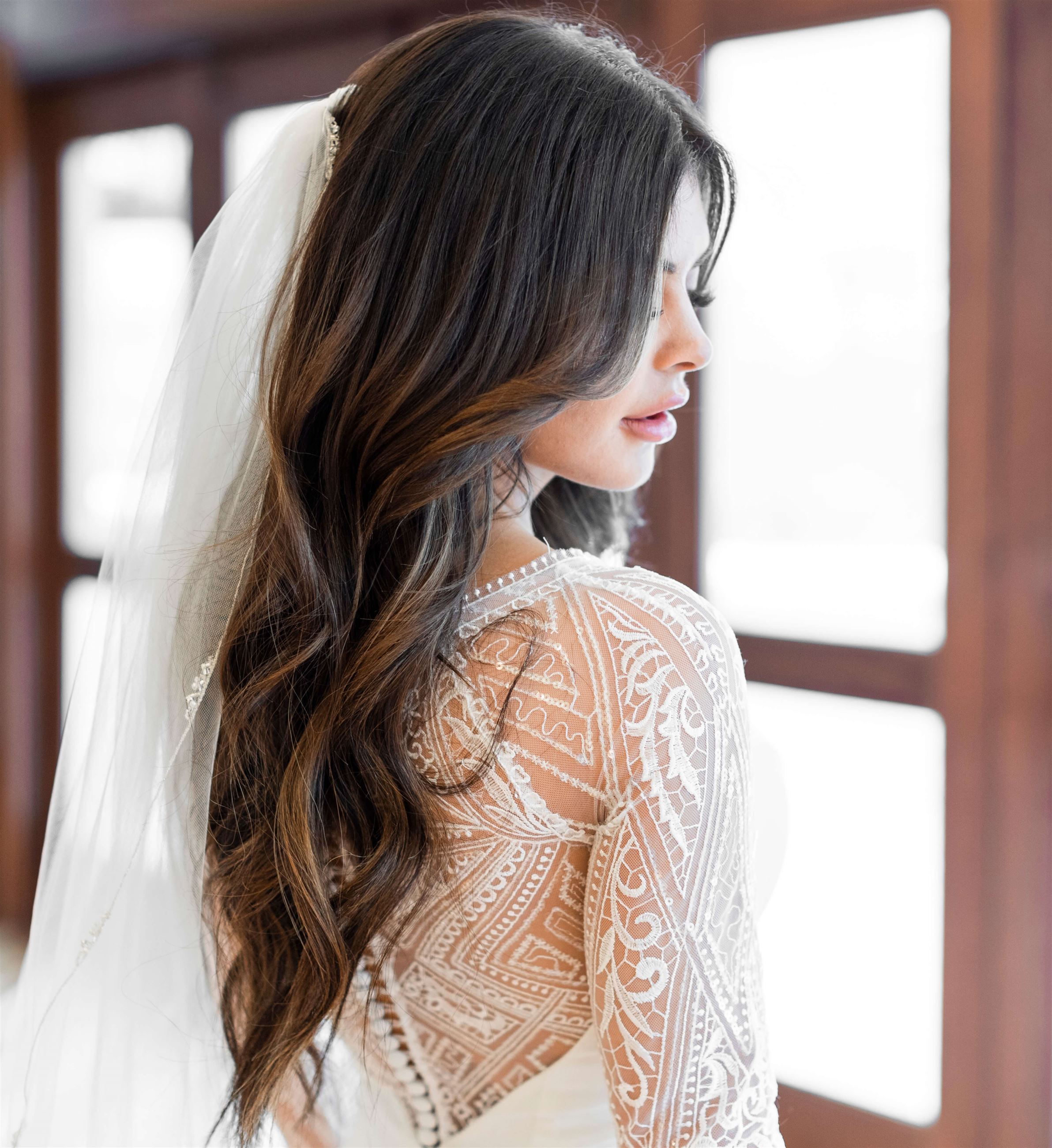 Bride in white long sleeved bridal dress with veil