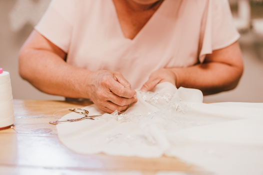 Seamstress sewing star embellishments onto white fabric